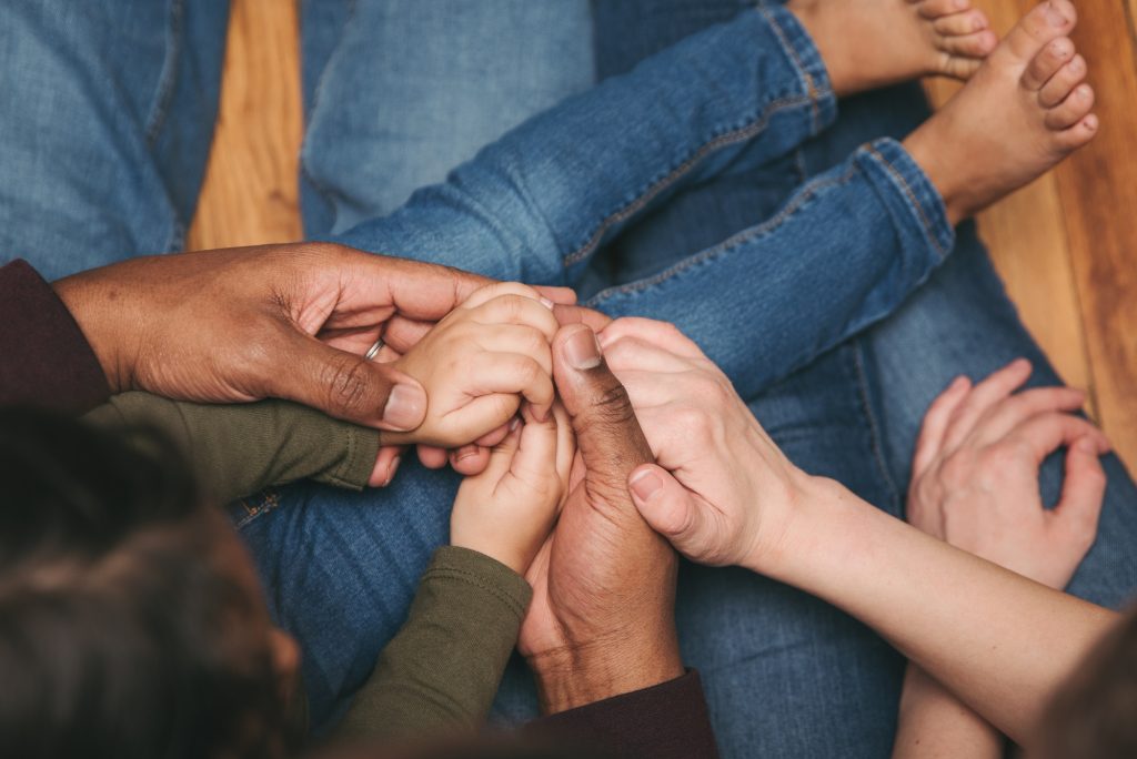 A multiracial family holding hands in love and support A multiracial family holding hands in love and support