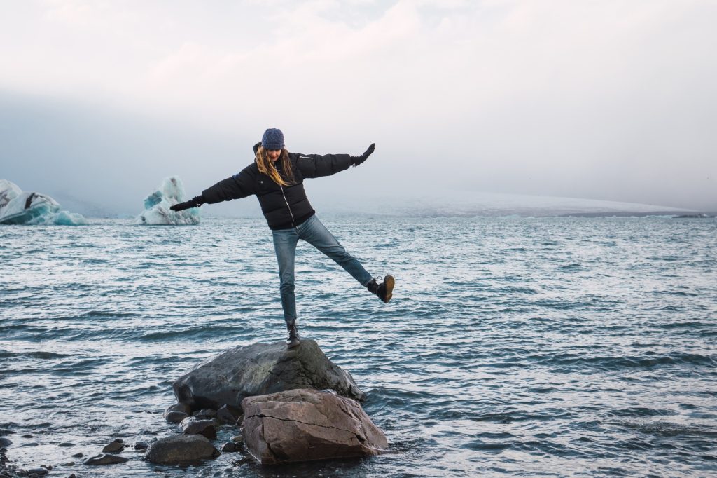 Happy girl balancing on rock in sea Happy girl balancing on rock in sea